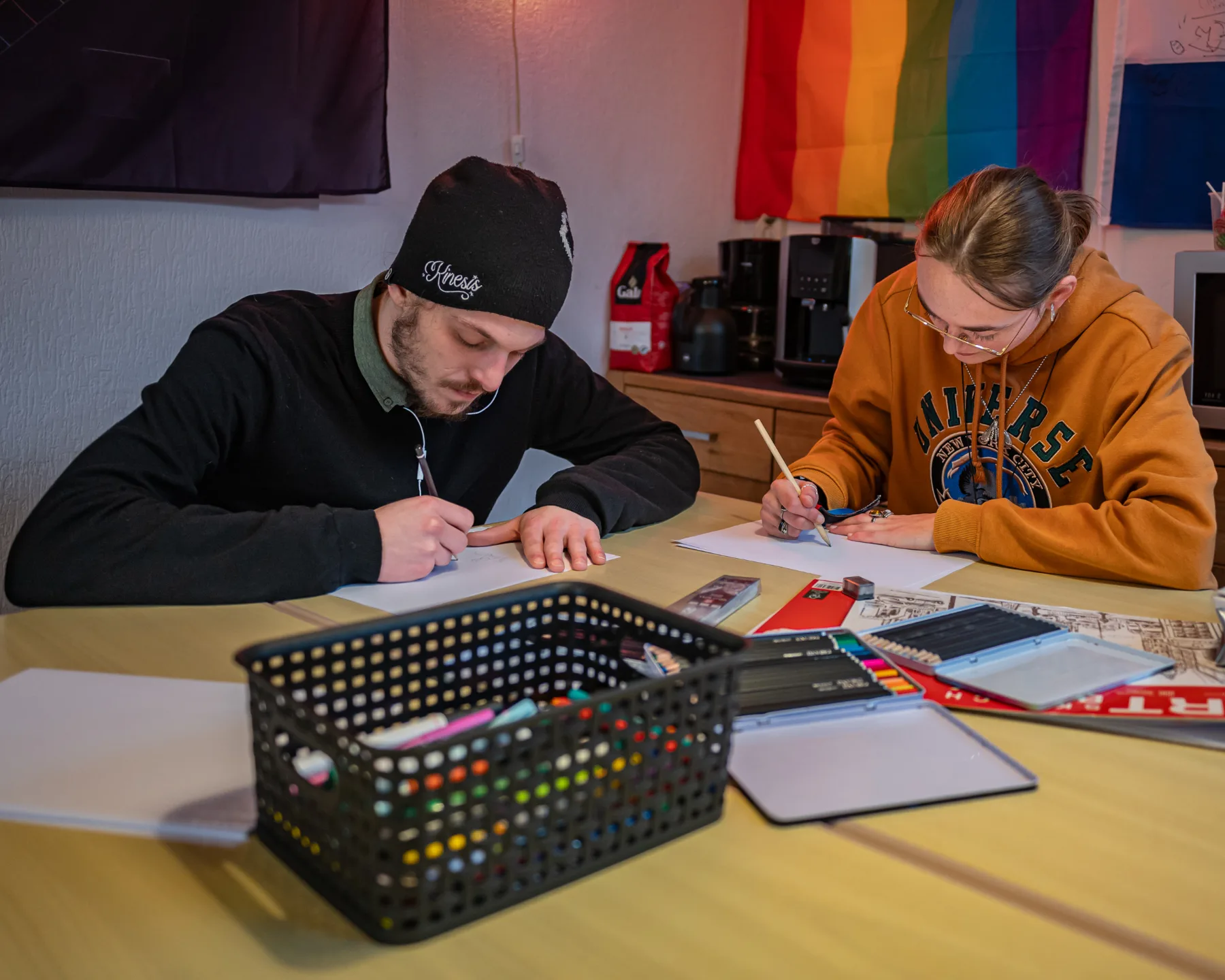 Jongeren tekenen samen aan tafel