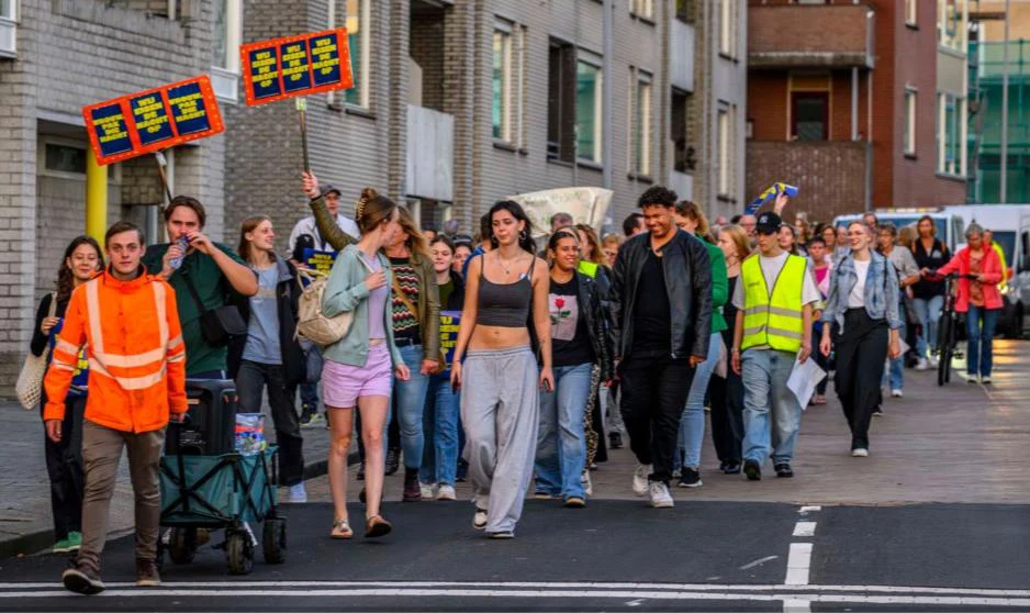 Een grote groep loopt met borden door de straat tijdens Wij eisen de nacht op